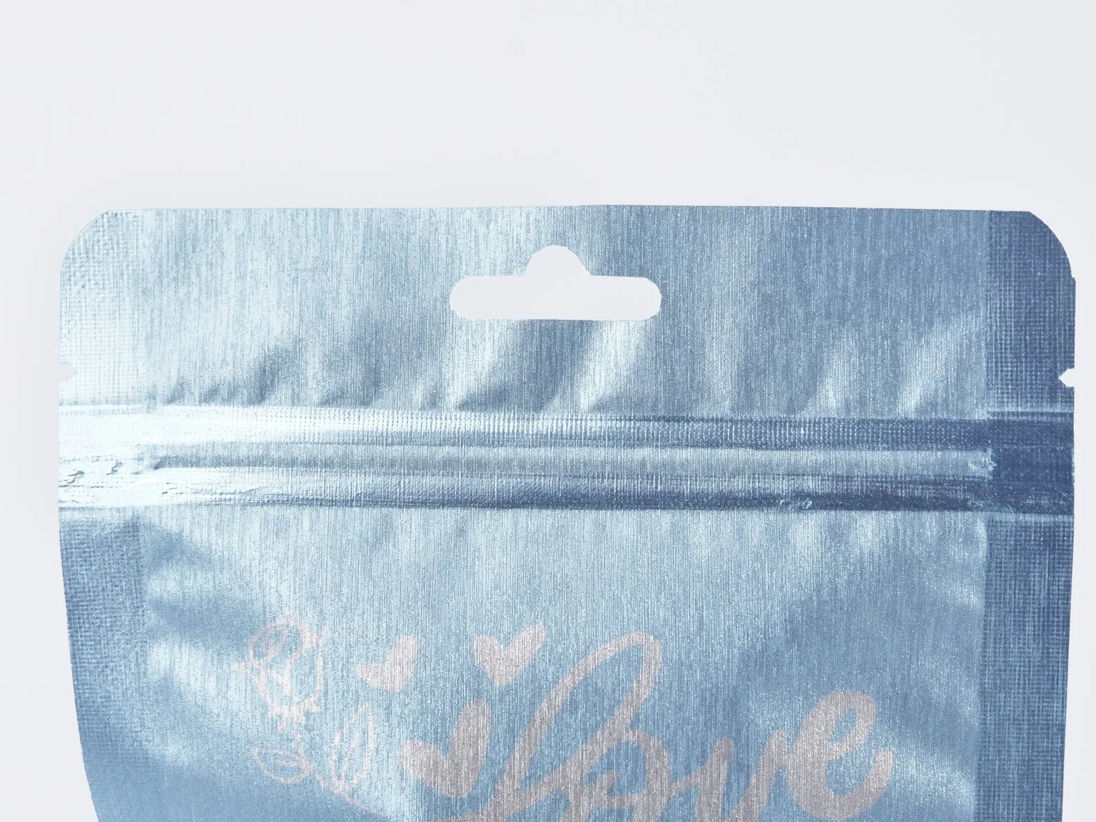 Light blue zipper pouch top with press-to-close zipper profile and hang hole